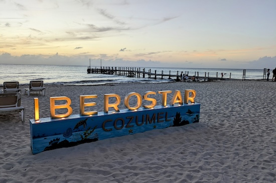Lighted sign on the beach that says "Iberostar"